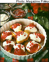 Bun slices topped with jam and cream in a white dish.
