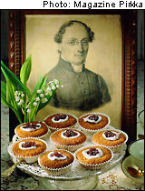 A tray of Runeberg tortes in front of a sepia portrait of J.L. Runeberg himself.