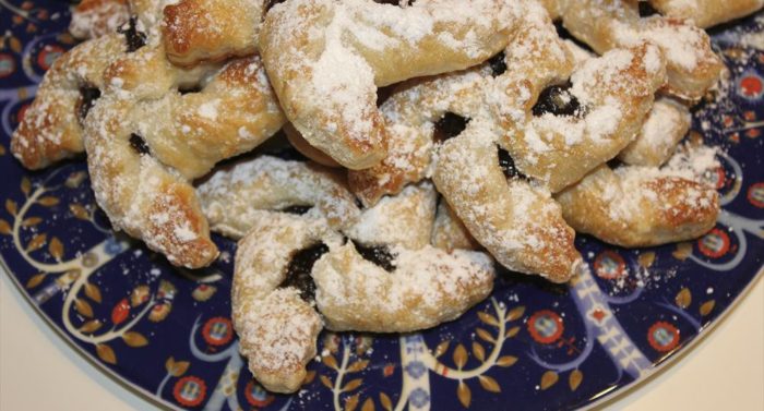 A pile of pinwheel-shaped Christmas pastries coated with powdered sugar.