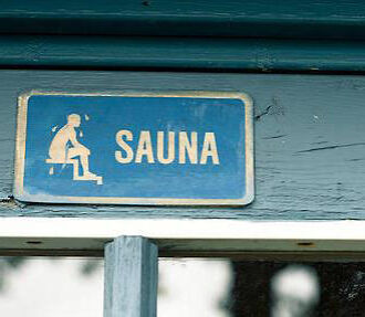 A sign on a wooden wall saying 'sauna'.