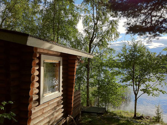 A small wooden sauna cabin by a lake.