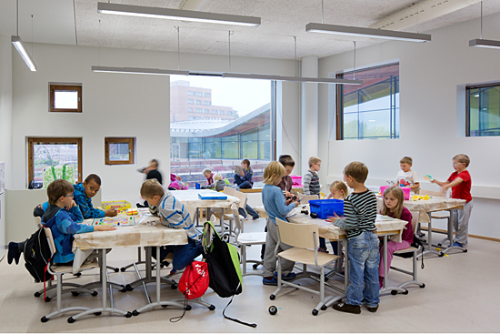 Schoolchildren studying in small groups around their desks.