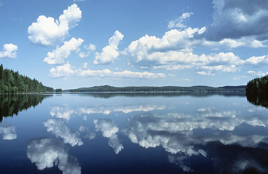 A clear lake reflecting the clouds on the sky.