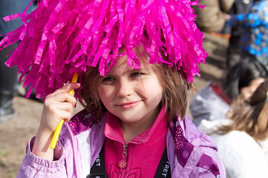 A young girl with a pink pompom.