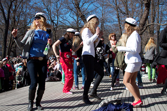 Students dancing outside on a wooden platform.