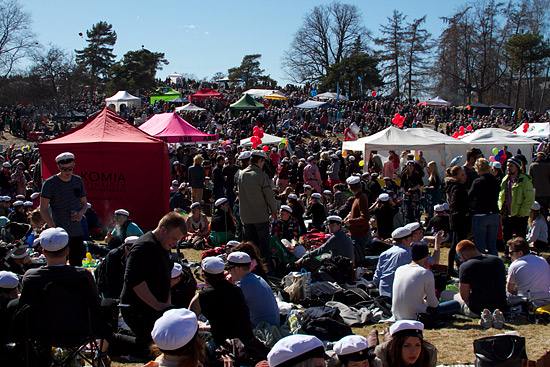 A park filled with picknickers; some with tents or canopies.