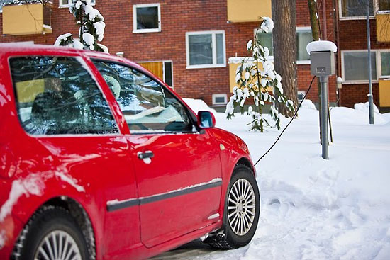 A red car attached to an engine-block heater. 