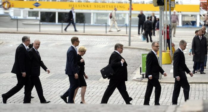 新内阁的成员们在前往新闻发布会的途中，路经一艘黄色的赫尔辛基观光游船。