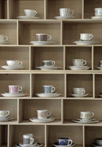 Different coffee cups on rectangular shelves.