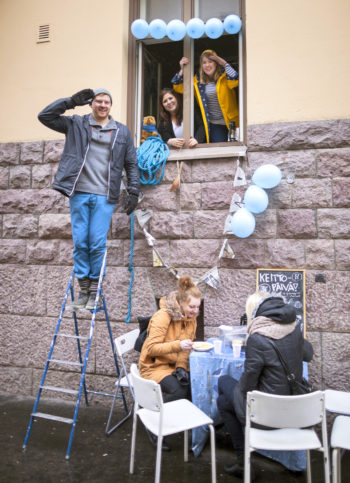Ресторанный день в Хельсинки. Вас приветствует персонал Keittopäivä! (перев. «Супный день!»): ПолКерник (Paul Kernick) слева, НоораВиртаниеми (Noora Virtaniemi)иМиаЛехто (Mia Lehto). Клиенты наслаждаются супом.