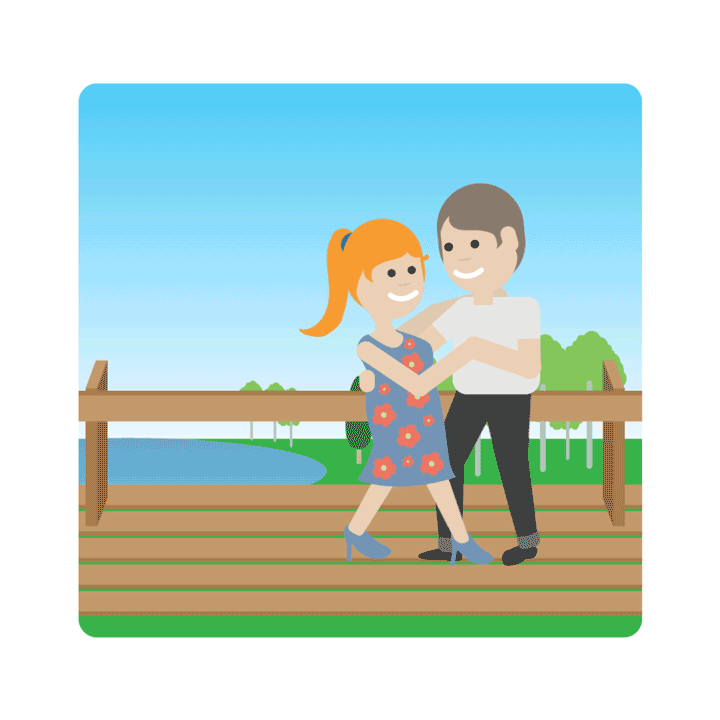 A smiling woman and man are dancing on an outdoor wooden platform, with a lake and some trees in the background.