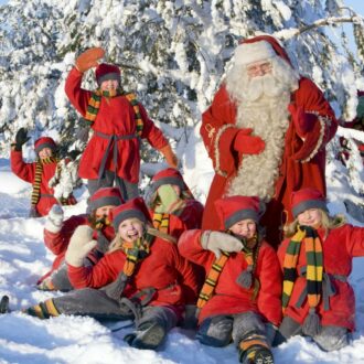 Santa Claus with children in a snowy landscape.