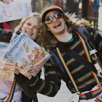 Two enthusiastic-looking students waving magazines.