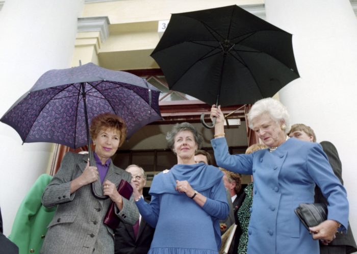 Raisa Gorbacheva, Tellervo Koivisto and Barbara Bush holding umbrellas.