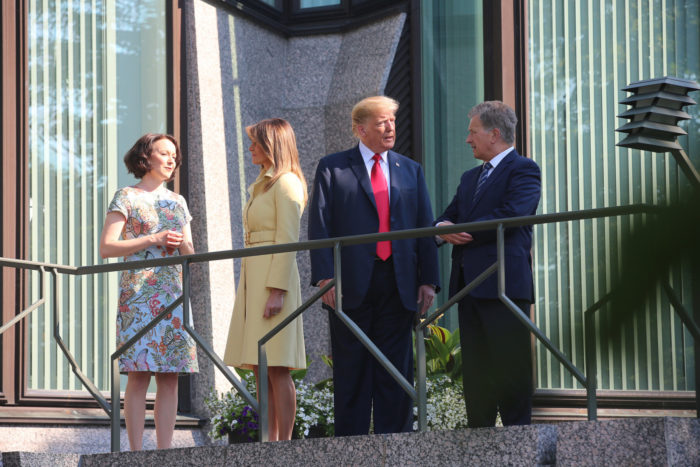 Sauli Niinistö and Jenni Haukio standing on a balcony with Donald and Melania Trump.