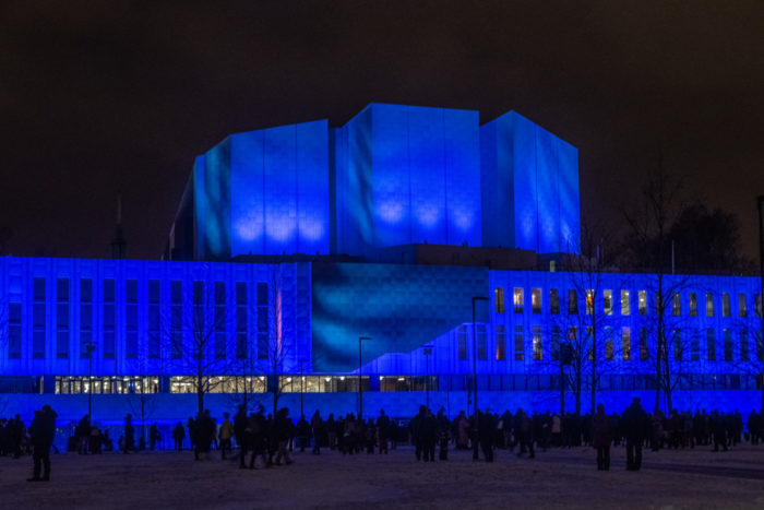 Finlandia hall in darkness, illuminated with deep blue lights.