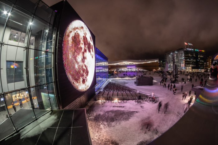 Helsinki Music Centre illuminated with a large full moon.