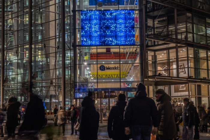 A deep blue light installation on the wall of Sanoma House.