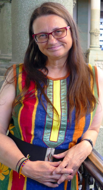 Portrait of a smiling Inger-Mari Aikio dressed in a colourful dress.