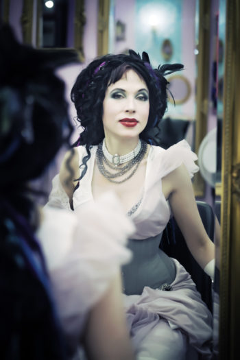 Portrait of author Sofi Oksanen sitting in front of a mirror.