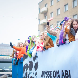 Celebrating students travelling on open-bed trucks dressed in different costumes.