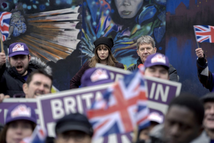 A crowd at a demonstration waving Union Jacks.
