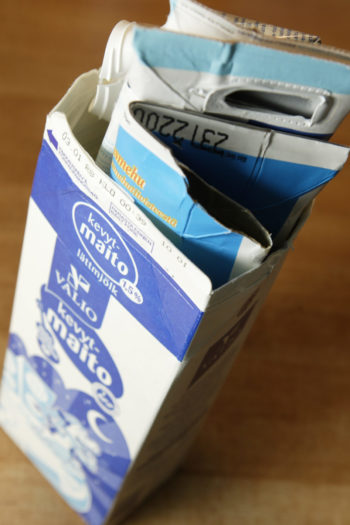 Compressed milk cartons stuffed inside another milk carton.