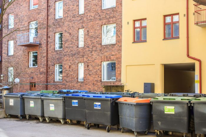 Recycling containers in front of a high-rise building.