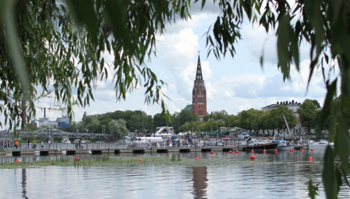 A river and a tall church tower in the horizon.