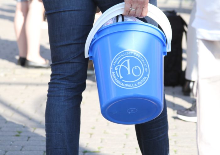 A person carrying a light blue plastic bucket.