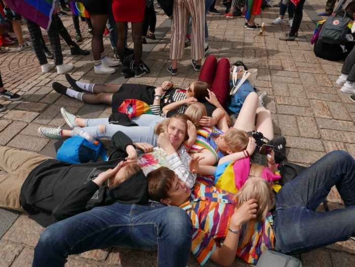 A group of smiling young people lying on the ground.