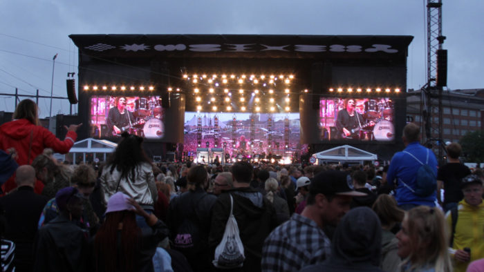 A large crowd in front of the main stage watches the Cure.