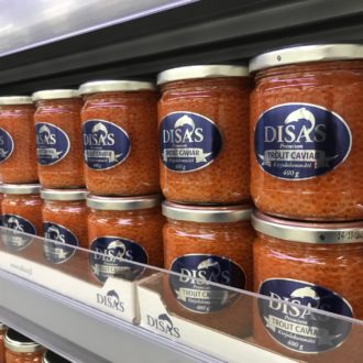 A shelf full of trout caviar in jars with a label that says “Disas”
