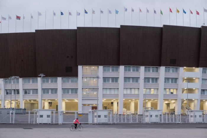 Uma vista externa do estádio mostra a silhueta do telhado, com segmentos que se erguem como degraus.