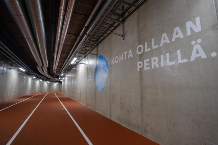 Ao lado de um trecho interno da pista de corrida, uma placa na parede diz “Quase lá” em finlandês.