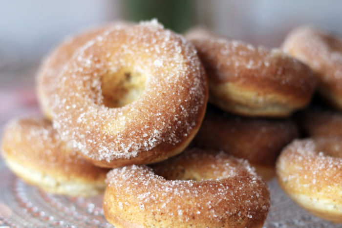 A close-up of a pile of sugar-coated doughnuts.