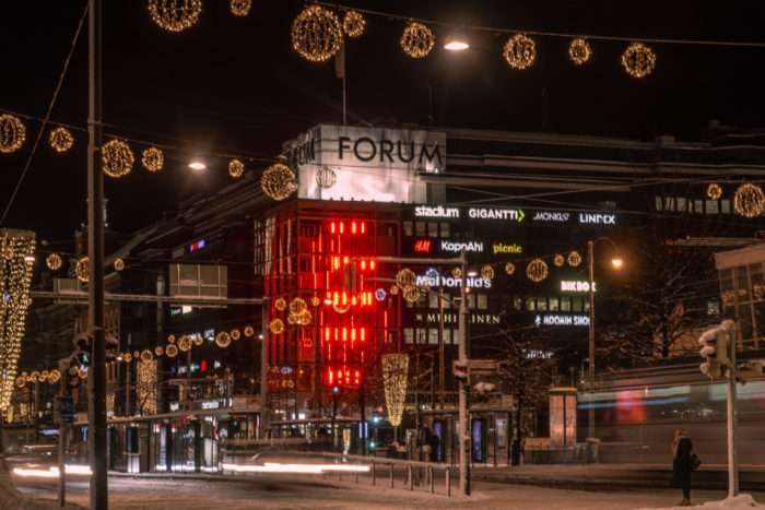 La esquina de un edificio se ilumina con haces verticales de luz roja.