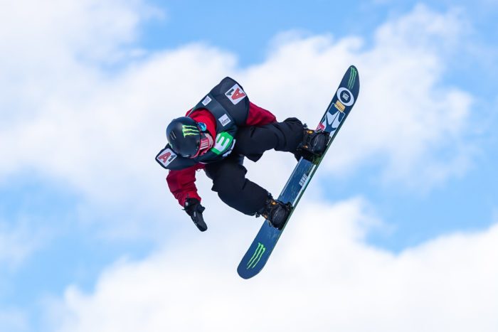 Ein Snowboarder in der Luft hebt sich als Silhouette vom Himmel ab.
