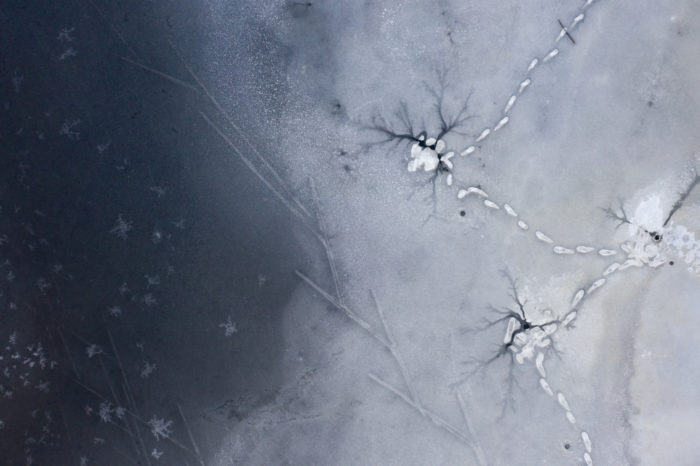 Vistas desde arriba, las huellas de esquís y de pisadas son visibles en la superficie del hielo y la nieve.