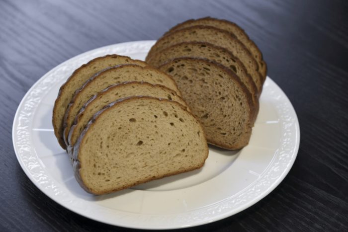 Um prato contém fileiras de fatias de pão escuro.