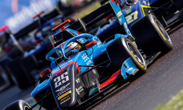 A driver steers a racecar along a track.