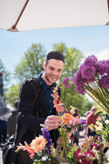 Мужчина выбирает цветы на рынке.