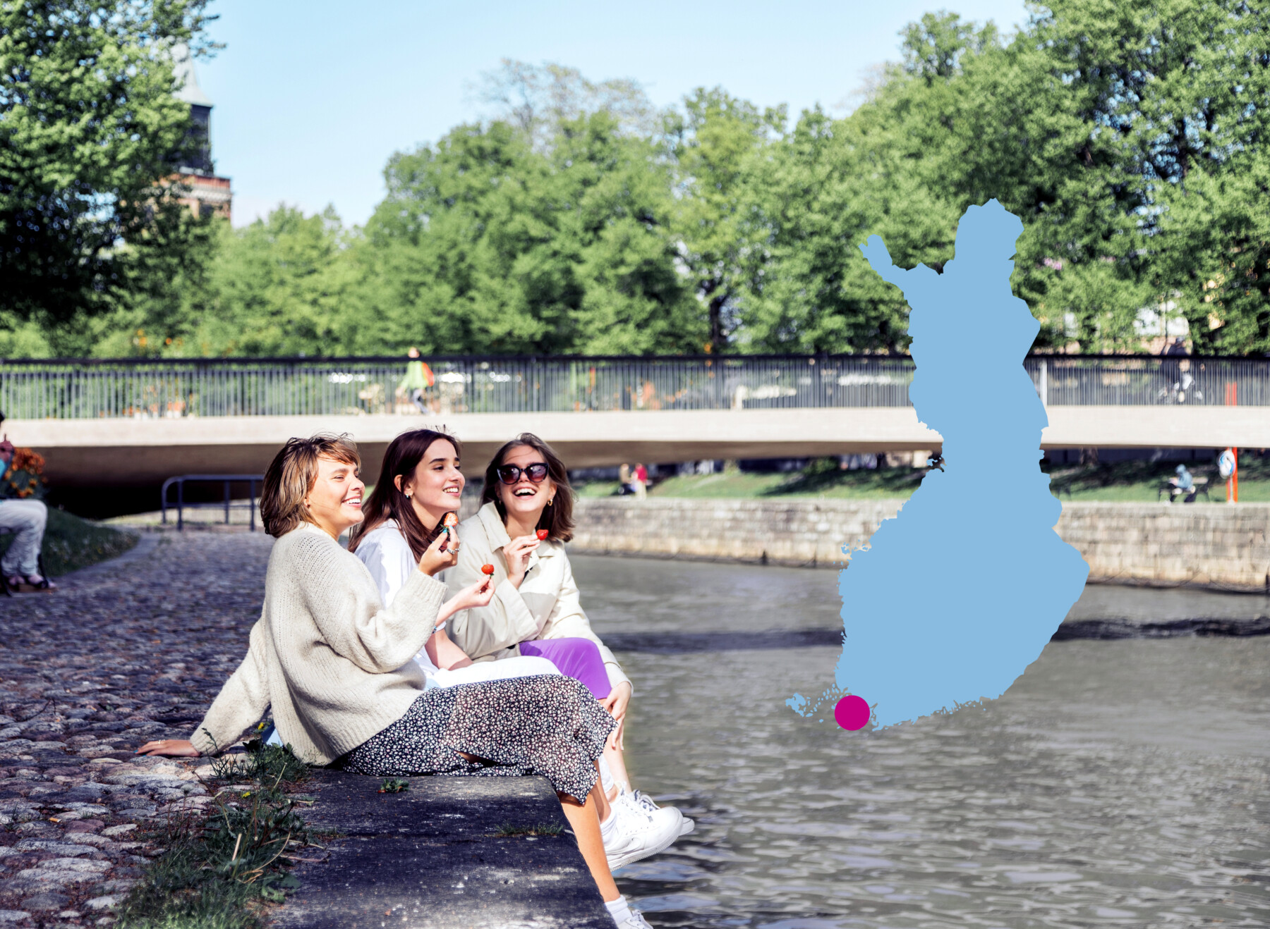 Три женщины едят клубнику, сидя на обсаженной деревьями набережной реки в городе Турку на юго-западе Финляндии (его локация отмечена красной точкой на голубом силуэте карты Финляндии).
