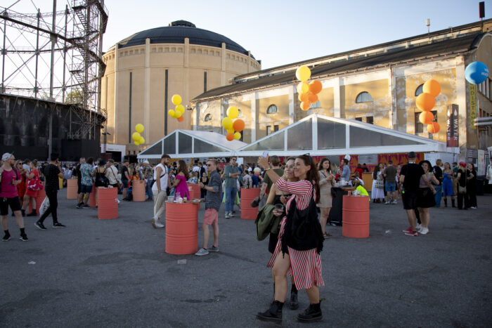 People walk past former industrial building on the festival grounds.