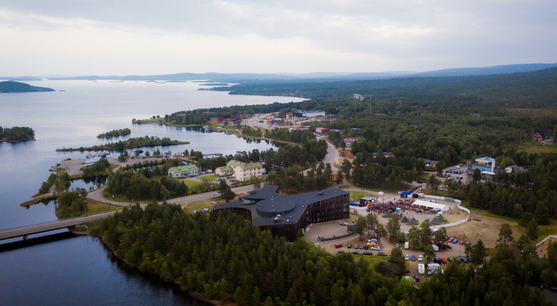 An aerial photo shows several clusters of buildings along the shore of a lake that stretches to the horizon.