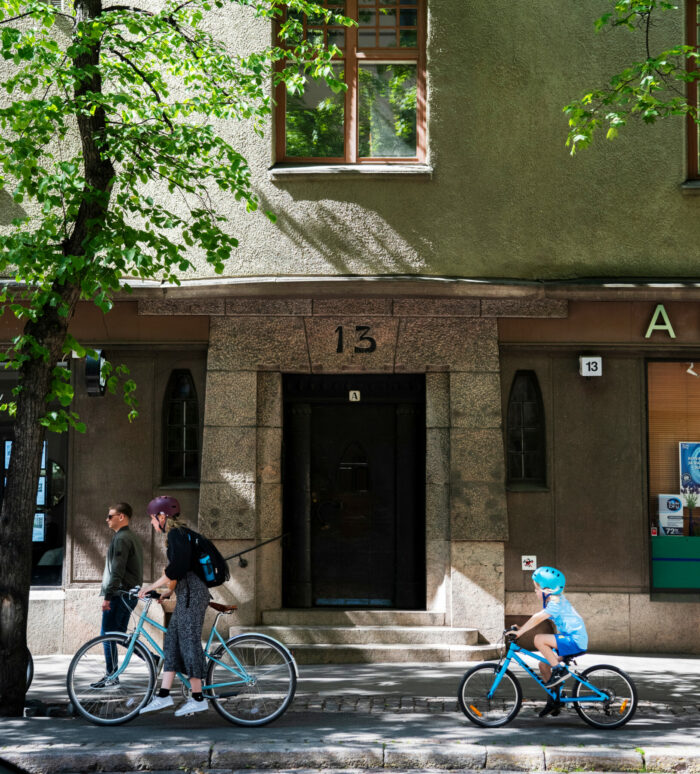 Uma variedade de edifícios residenciais em Helsinque, a maioria com fachadas suaves e detalhes ornamentais como torres, sacadas, frontões e janelas salientes que lembram a arquitetura de castelos.