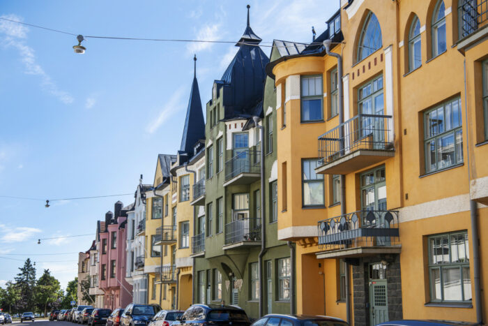 Varios edificios residenciales de Helsinki, la mayoría con fachadas lisas y detalles ornamentales como torreones, balcones, gabletes y ventanales que recuerdan a la arquitectura de los antiguos castillos.