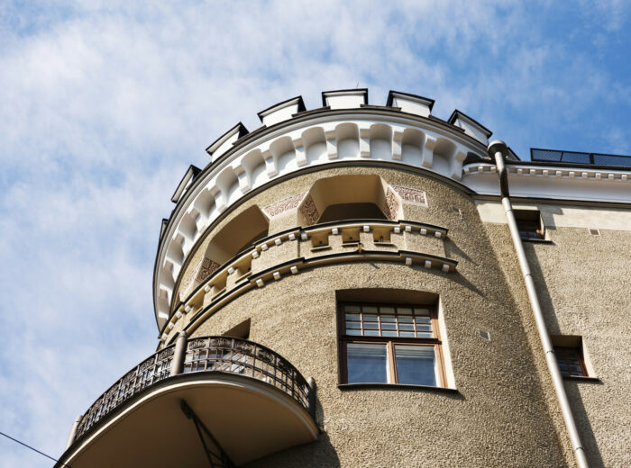 Varios edificios residenciales de Helsinki, la mayoría con fachadas lisas y detalles ornamentales como torreones, balcones, gabletes y ventanales que recuerdan a la arquitectura de los antiguos castillos.