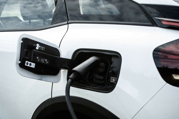 A charging cord is plugged into an electric car.