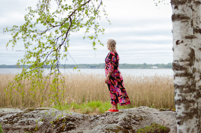 A woman standing by a lake.